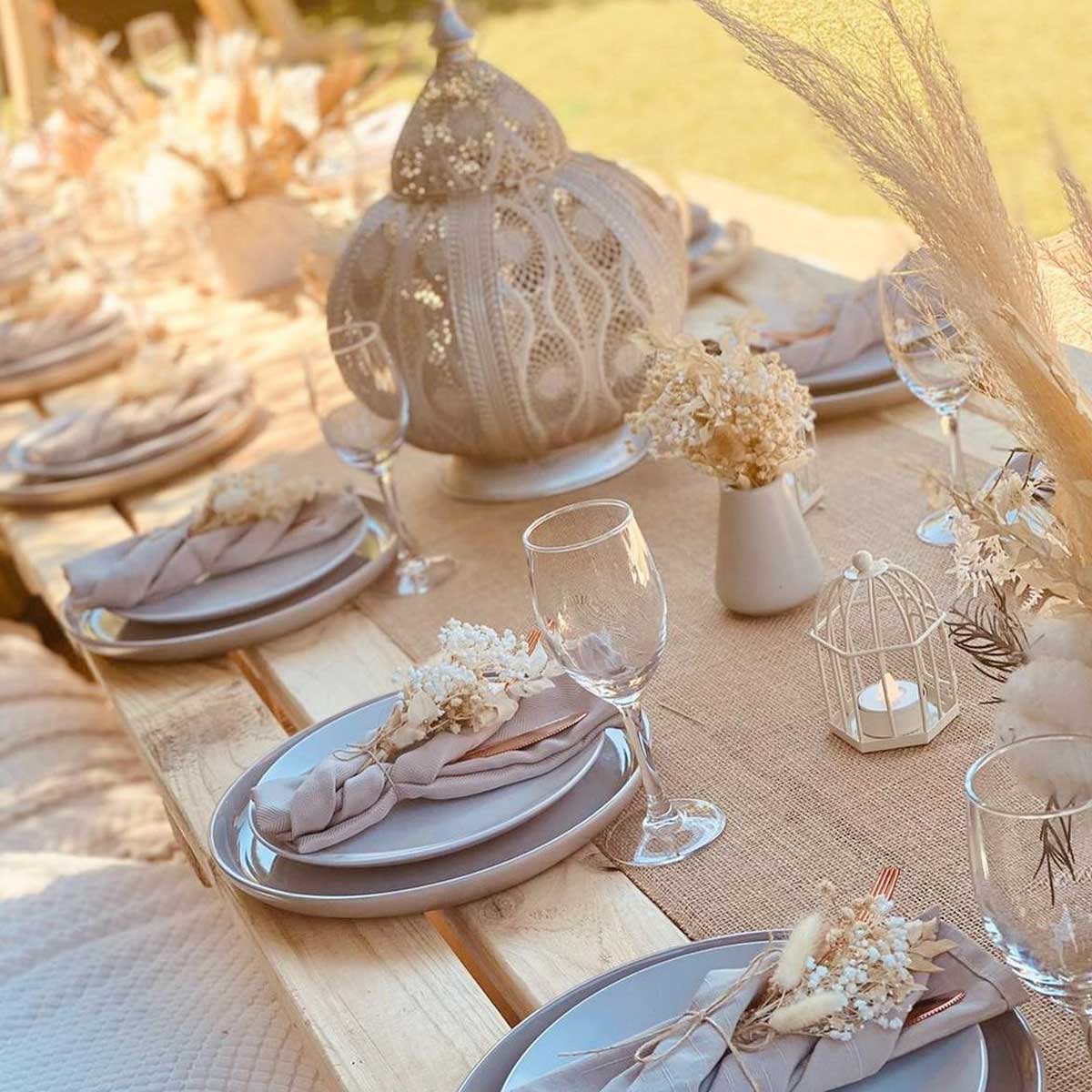 Chic and timeless bridal shower luxury picnic setup in Melbourne. Chic and timeless bridal shower luxury picnic in Melbourne featuring neutral toned tableware, soft linens, elegant glassware, and classic floral decor on a natural wooden table.