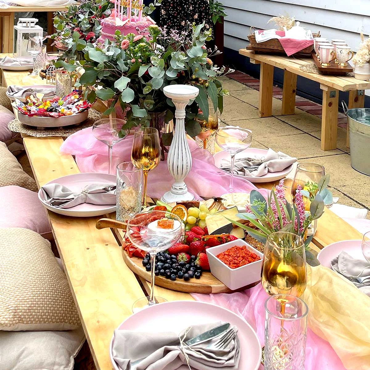 Elegant birthday picnic setup in Melbourne with grazing platter, pink birthday cake, floral decor and luxe hire tableware.